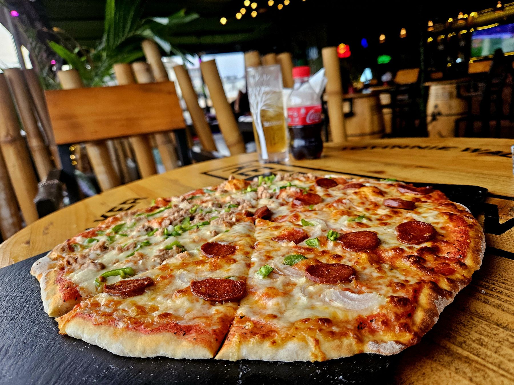 Pizza chorizo et poivrons servie sur une table tonneau au Pichichi